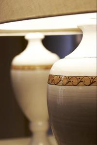 zwei weiße Vasen nebeneinander sitzen in der Unterkunft Hotel & Residenza 100 Torri in Ascoli Piceno