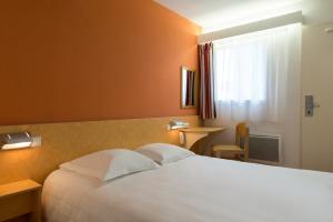 a hotel room with a bed and a window at The Originals Access, Hôtel Saint-Flour (P'tit Dej-Hotel) in Saint-Flour