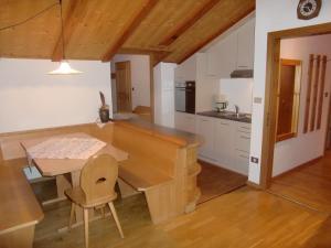 a kitchen with a wooden table and a dining room at Residence Texel in Pfelders