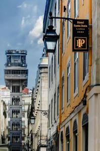 una via cittadina con edifici e una torre dell'orologio di Hotel Santa Justa a Lisbona