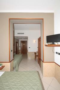 米蘭的住宿－阿斯特麗德酒店，客房设有带镜子和电视的卧室。