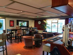 a restaurant with a bar with chairs and tables at The Runmere Hotel, Liverpool South Runcorn, Part of the AG Collection in Runcorn