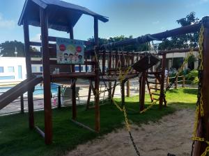 a wooden playground with a slide and a chain at Verano Praia Ponta Negra AP 1401 in Natal