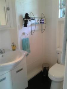 a white bathroom with a sink and a toilet at Palm Cottage in Castries