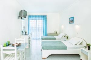 Postel nebo postele na pokoji v ubytování Xenios Port Marina Hotel