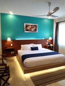 1 dormitorio con 1 cama grande y pared verde en Araucaria Hotel Boutique, en Valle de Bravo