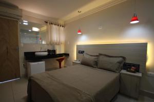 - une chambre avec un grand lit et un lavabo dans l'établissement Bob Motel, à São Paulo