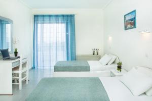 Postel nebo postele na pokoji v ubytování Xenios Port Marina Hotel