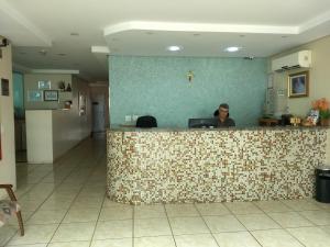 a woman sitting at a counter in a hospital at Hotel Soldera Inn in Sertãozinho