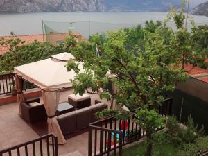 a gazebo on a balcony with an orange tree at Appartamento Morena in Malcesine