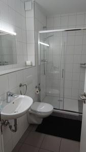 a bathroom with a shower and a toilet and a sink at Gästehaus Schmitt in Erlangen