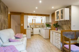 ein Wohnzimmer mit einer weißen Couch und einer Küche in der Unterkunft Apartment Ivanka Cvetek in Bohinj