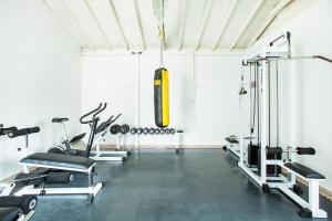 a gym with cardio equipment in a white room at Xenios Port Marina Hotel in Pefkochori