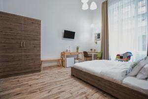 Dormitorio con cama, escritorio y TV en Budapest Passage 1, en Budapest
