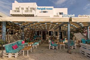 a patio with chairs and tables under a pavilion at Perigiali Rooms & Apartments Folegandros in Agali
