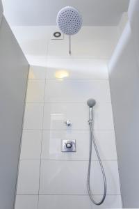 a shower with a shower head in a bathroom at Botanik Hostel in Poznań