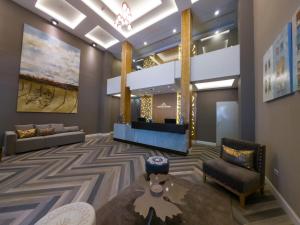 vestíbulo con zona de espera con sofá y sillas en Fuente Mayor Hotel Centro en Mendoza
