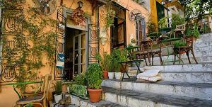 a building with potted plants on the side of it at Nephiria's Art House, Under the Acropolis! in Athens