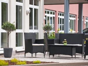 un grupo de sillas y mesas en un patio en ACHAT Hotel Chemnitz, en Chemnitz