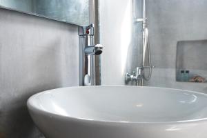a white sink in a bathroom with a window at Perigiali Rooms & Apartments Folegandros in Agali