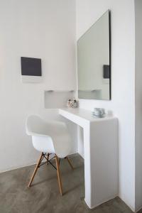 a white desk with a chair and a mirror at Perigiali Rooms & Apartments Folegandros in Agali
