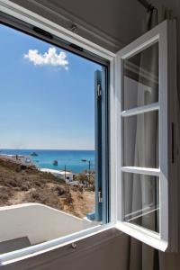 a window with a view of the ocean at Perigiali Rooms & Apartments Folegandros in Agali