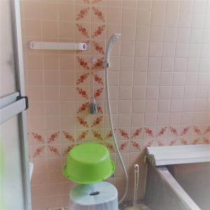 a shower with a green bucket in a bathroom at Minshuku Mariko / Vacation STAY 895 in Mochimune