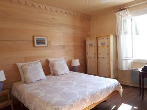 um quarto com uma cama com paredes de madeira e uma janela em Sûn Chambres d'hôtes em Rabastens