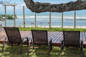 dwa krzesła i stół z plażą w tle w obiekcie Aquarela Praia Hotel w mieście Arraial d'Ajuda