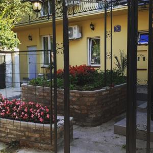 uma casa com flores em frente a uma cerca em Male stepenice em Belgrado