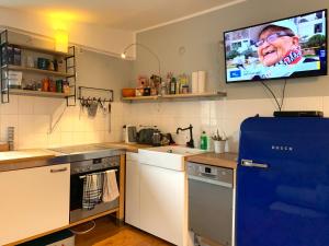 a kitchen with a tv hanging on the wall at Hinterhaus Apartment No1 in Leipzig
