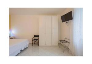 Casa Palomba 41 في مينوري: غرفة نوم بسرير وتلفزيون بشاشة مسطحة