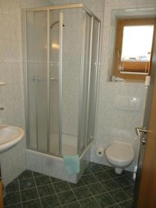 a bathroom with a shower and a toilet and a sink at Hotel-Pension Theresa in Rauris