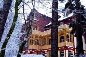ゴスラーにあるForest-Lodgeの木の雪の赤黄色い家