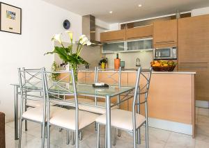 a kitchen with a glass table and chairs at Apartment CB 1 in Alcudia