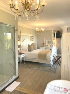 um quarto com uma cama grande e um lustre em A Kings View em Eshowe