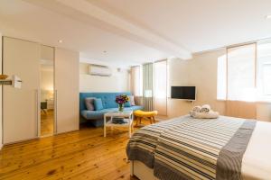 a bedroom with a bed and a couch and a table at Apartments Tereza in Dubrovnik