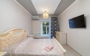 - une chambre avec un lit et une télévision à écran plat dans l'établissement Apartments Deribasovskaya, à Odessa