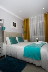 ナザレにあるFerhouse Dreams Pátriaのベッドルーム(緑と白の大型ベッド1台付)