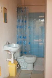 a bathroom with a toilet and a sink at Hospedaje Costa Norte in Máncora