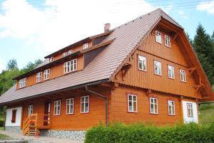una gran casa de madera con techo de gambrel en Roubenka-Mila, en Ostružná
