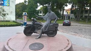 a statue of a woman sitting on a motorcycle at West coast apartments in Klaipėda
