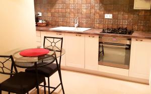 eine Küche mit einem Tisch, 2 Stühlen und einem Waschbecken in der Unterkunft Central Apartment DumDix Brasov in Braşov