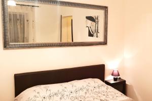 a mirror above a bed in a bedroom at Central Apartment DumDix Brasov in Braşov