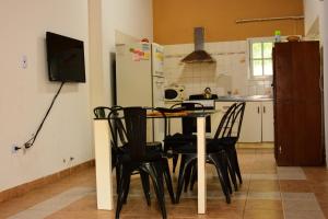 cocina con mesa, sillas y nevera en Apartamento Los Abuelos Calle Esteva Berga en Colón