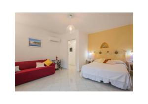 a bedroom with a bed and a red couch at Casa Palomba 41 in Minori