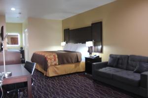 Habitación de hotel con cama y sofá en Express Inn and Suites, en Humble