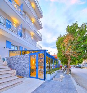 a building with a blue facade and stairs next to a street at Dias Hotel in Alexandroupoli