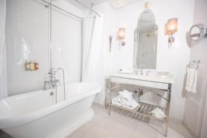 a white bathroom with a tub and a sink at The Culver Hotel in Los Angeles