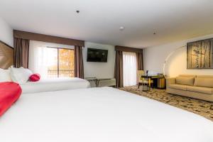 Habitación de hotel con 2 camas y sofá en Regalia Hotel & Conference Center, en Lake Ozark